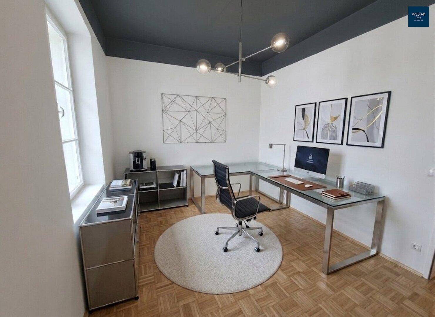 Modernes Arbeitszimmer mit großem Schreibtisch, minimalistischer Einrichtung und dunkler Decke.
