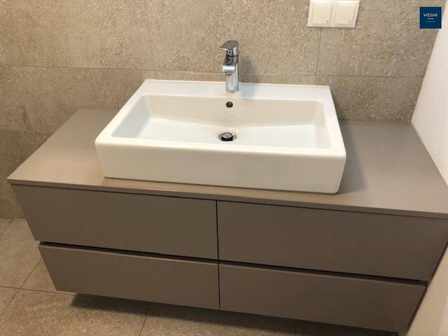 Detailaufnahme des modernen Waschtischs mit Aufsatzbecken und praktischem Unterschrank im Badezimmer.