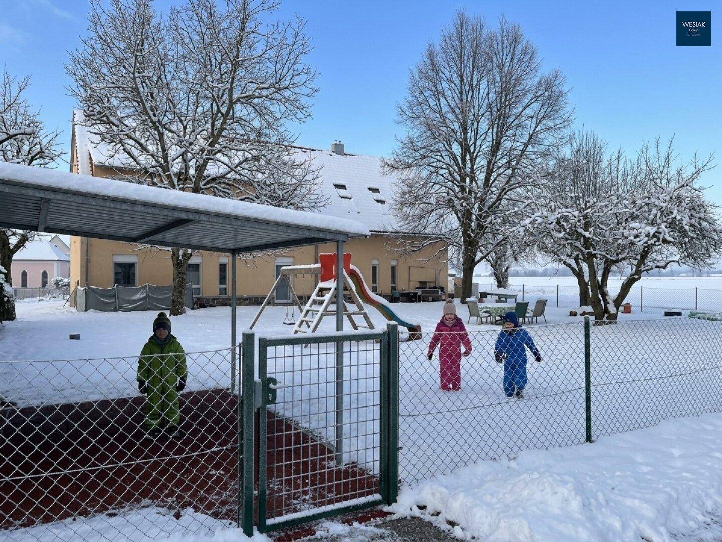 Winterliche Ansicht des Spielplatzes im Garten, bedeckt mit frischem Schnee.