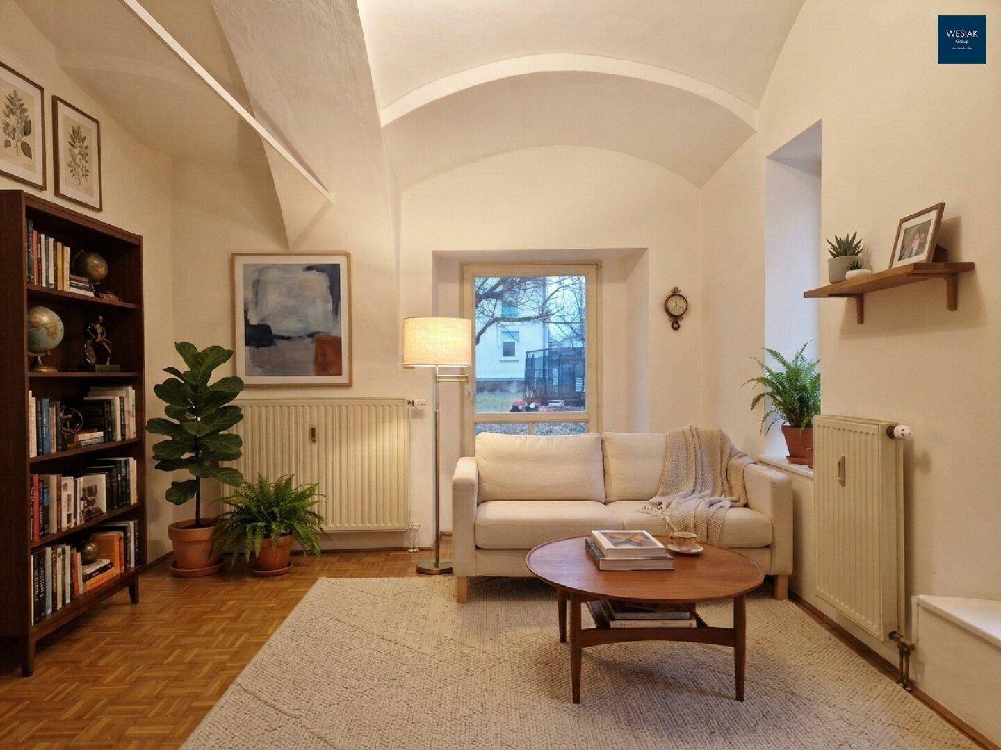 Gemütliches Wohnzimmer mit Sofa, Bücherregal und charakteristischer Gewölbedecke.