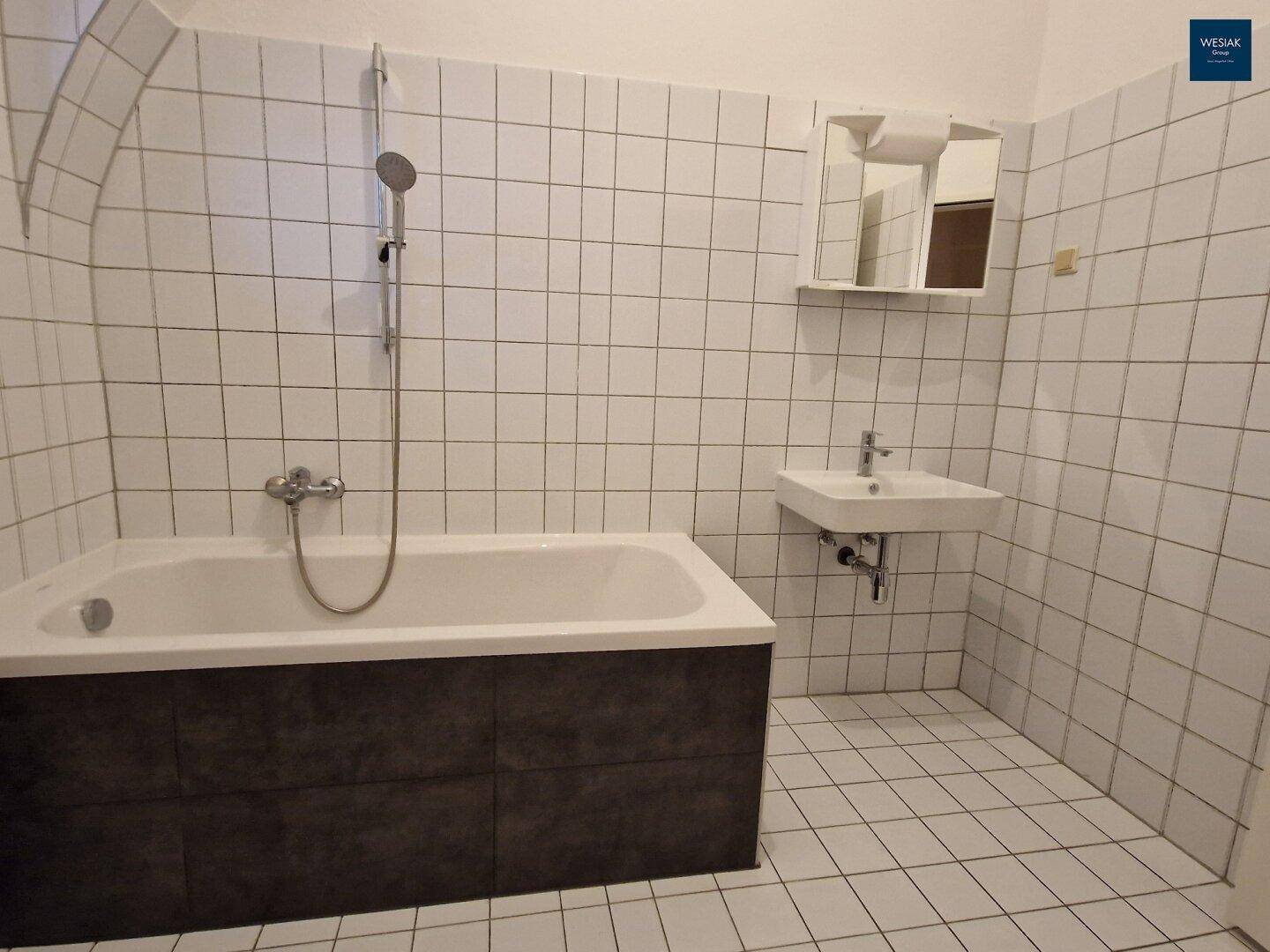 Leeres Badezimmer mit Badewanne und weißen Wandfliesen, bereit zur Einrichtung.