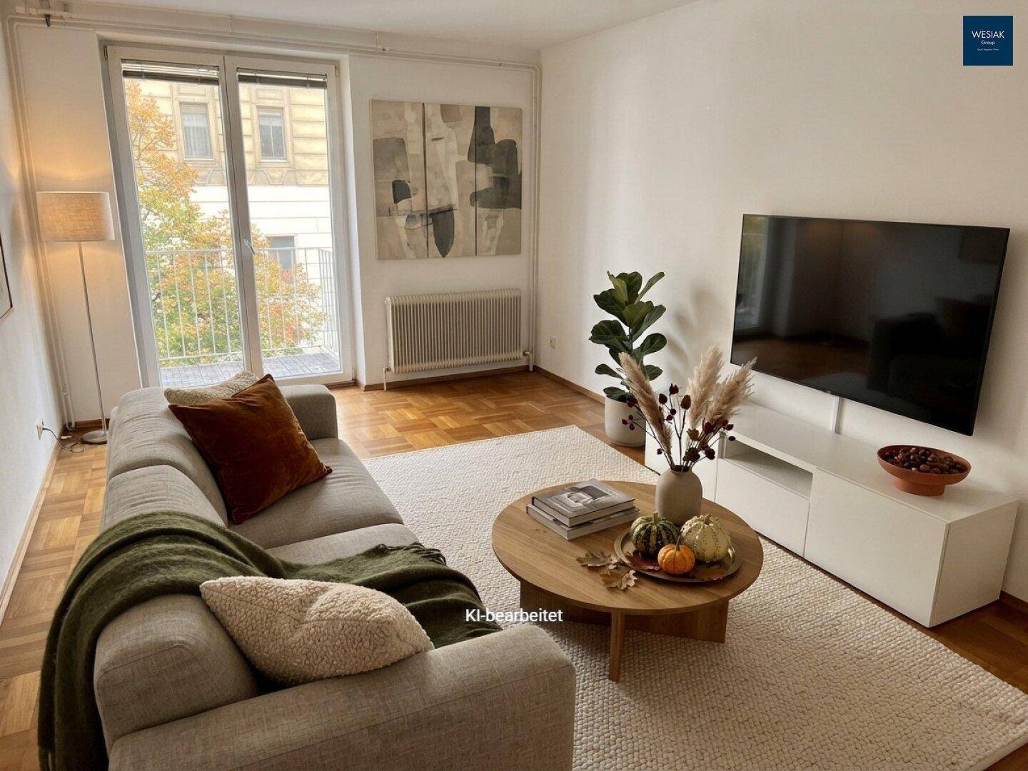 Helles Wohnzimmer mit beiger Couch, Holztisch und Blick auf den französischen Balkon.