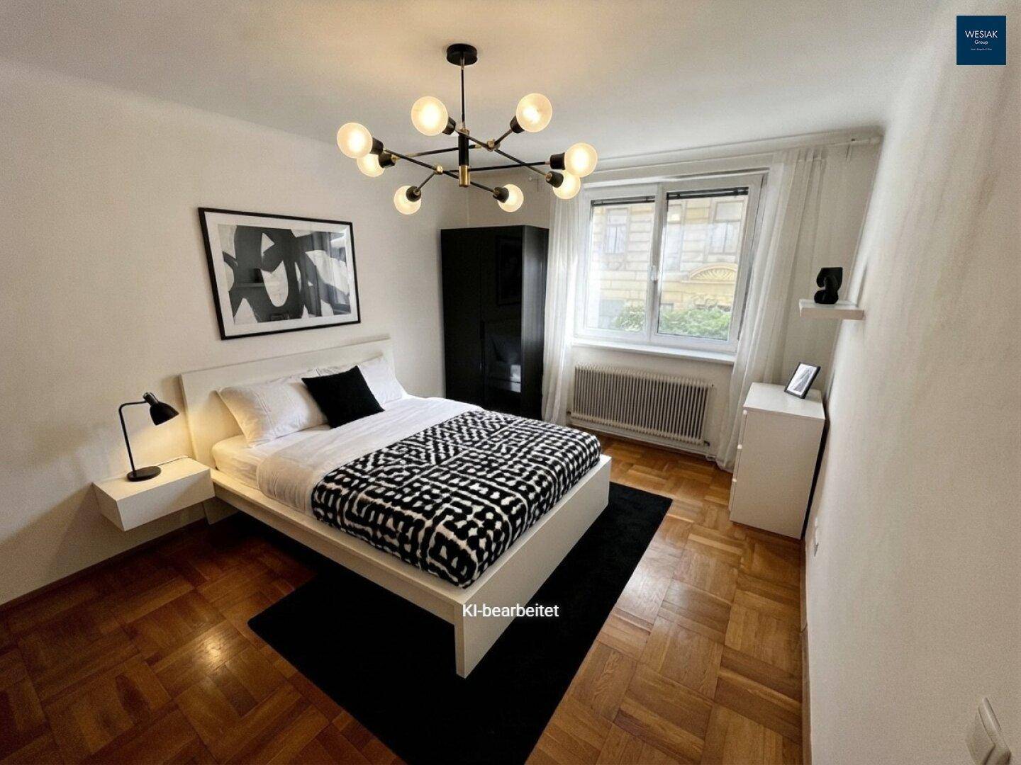 Helles Schlafzimmer mit Doppelbett, dunklem Kleiderschrank und Parkettboden.
