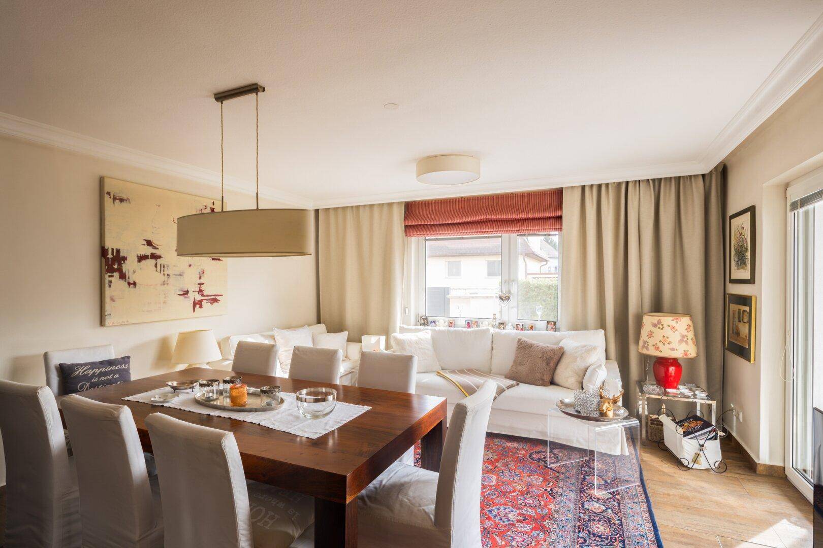 Heller Wohnbereich mit Sofa, Esstisch und Zugang zur Terrasse.