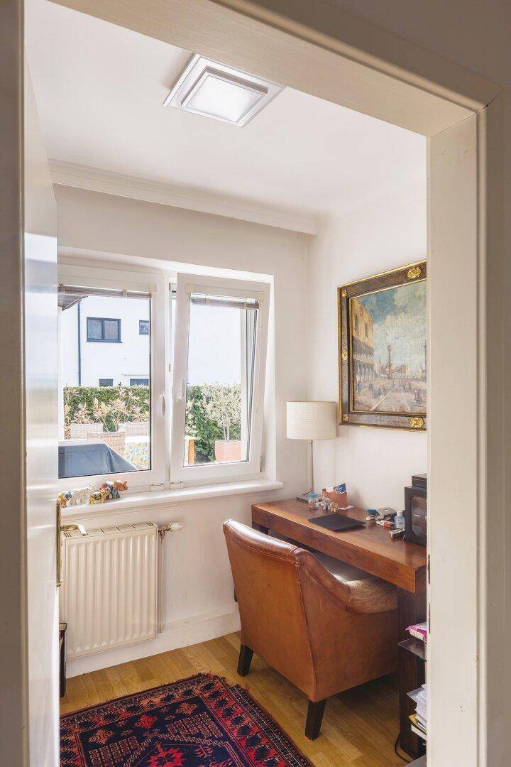 Kleines, helles Büro mit Schreibtisch, Ledersessel und Fensterblick.