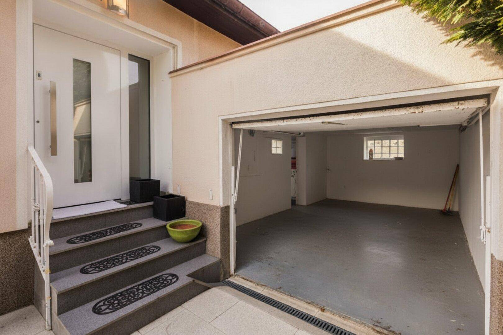 Eingangsbereich des Hauses mit Treppe und offener Garage.