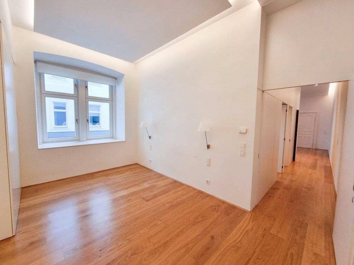Helles Zimmer mit Holzboden und Fenster, das sich gut als Schlaf- oder Gästezimmer eignet.