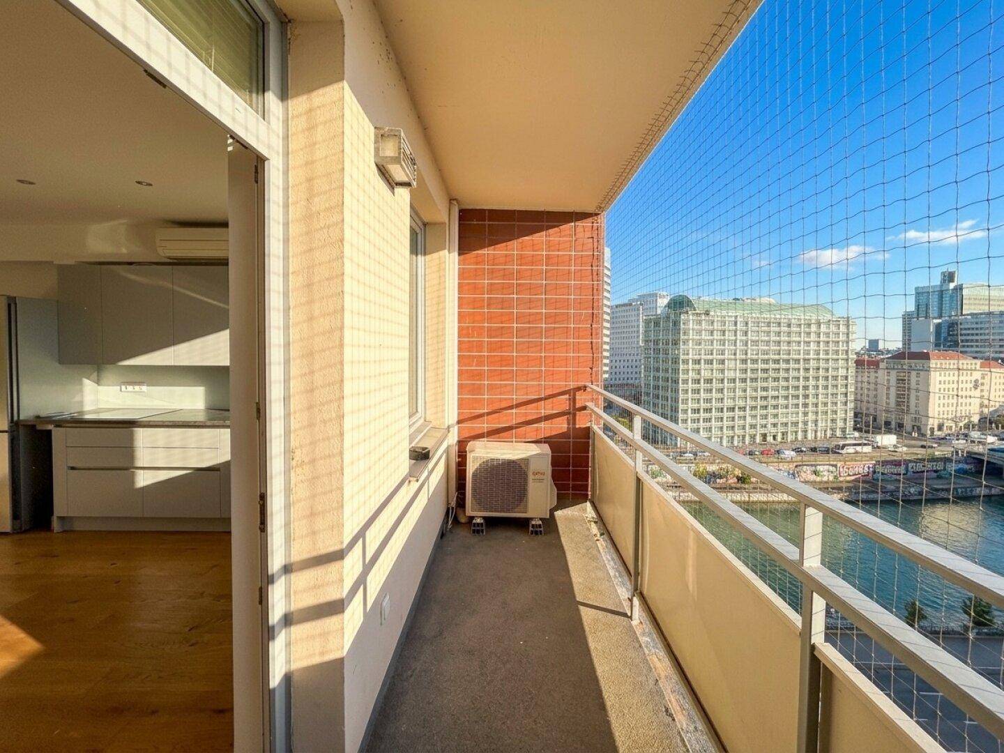 Schmaler Balkon mit Sicherheitsnetz und Blick auf die Stadt und den Fluss, zugänglich von der Küche.