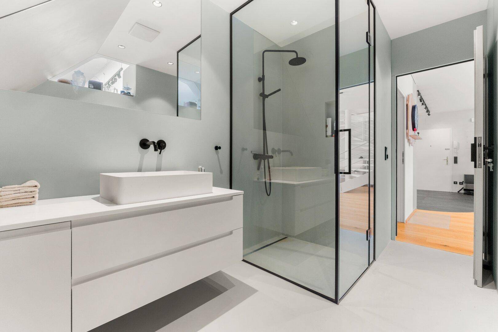 Modernes Badezimmer mit begehbarer Dusche, Aufsatzwaschbecken und minimalistischem Design.