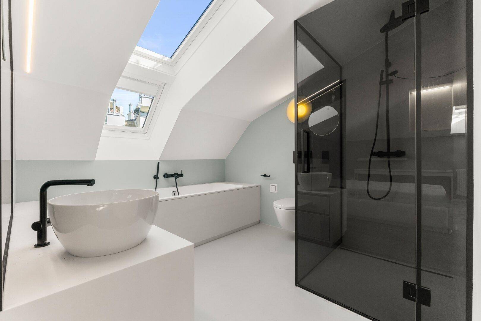 Modernes Badezimmer mit Badewanne, Aufsatzwaschbecken und begehbarer Dusche mit dunklem Glas.