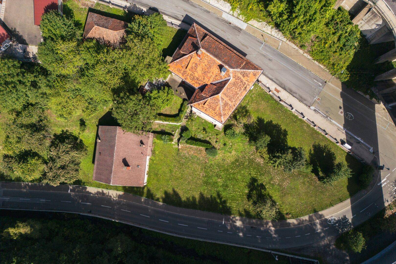 Luftaufnahme des Anwesens mit mehreren Gebäuden und großem Gartenbereich.