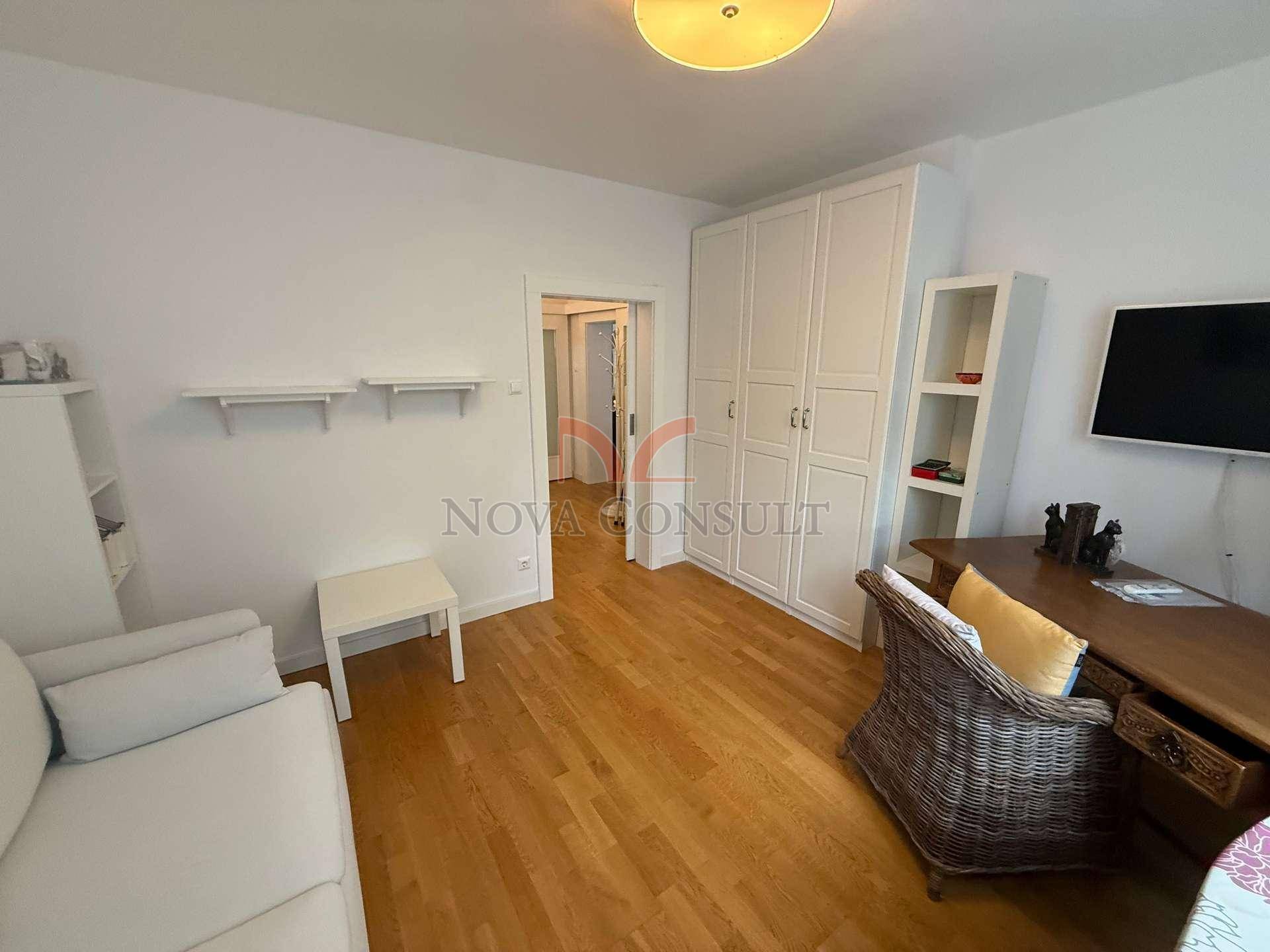 Arbeitszimmer mit Parkettboden, weißen Schränken und Blick in den Flur, funktional eingerichtet.