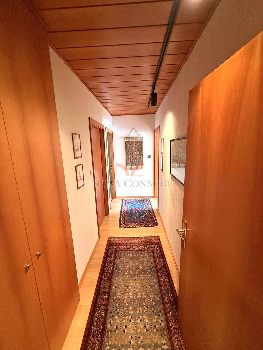 Langer Flur mit Holzdecke, Parkettboden und traditionellen Teppichläufern.