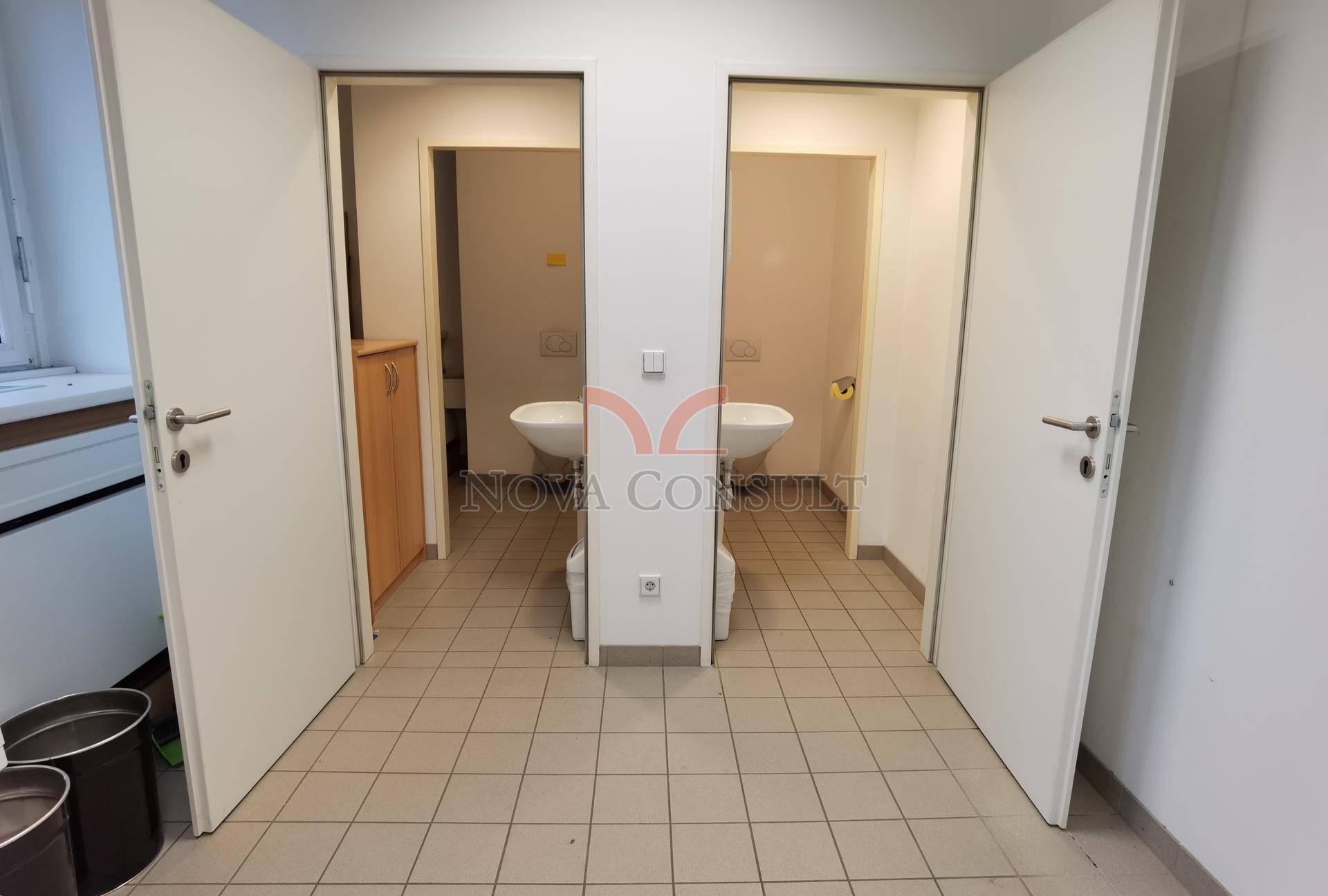 Zwei separate Toilettenräume mit Waschbecken und WC, zugänglich durch einzelne Türen.