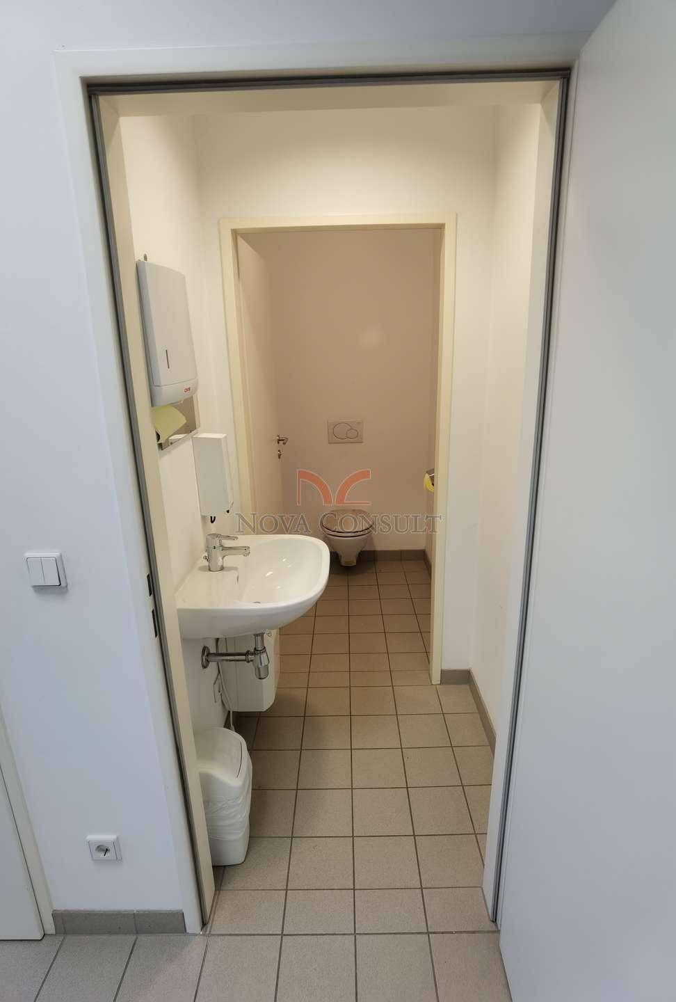 Kleiner Toilettenraum mit Waschbecken und WC, ausgestattet mit Fliesenboden.