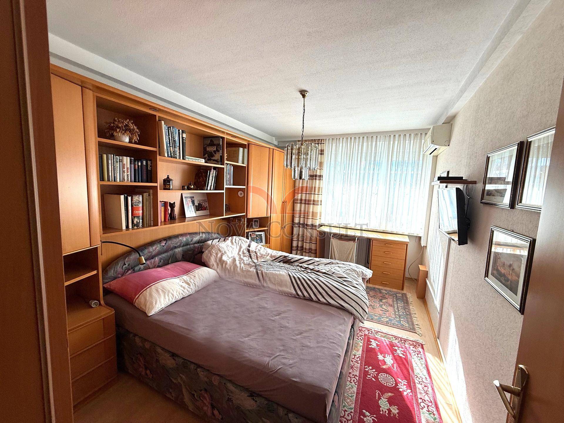 Gemütliches Schlafzimmer mit Doppelbett, eingebauten Regalen und Klimaanlage.