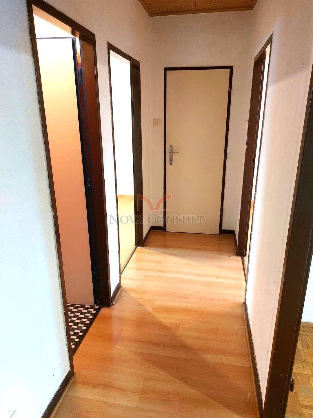 Heller Flur mit Laminatboden, der zu verschiedenen Zimmern im Haus führt.