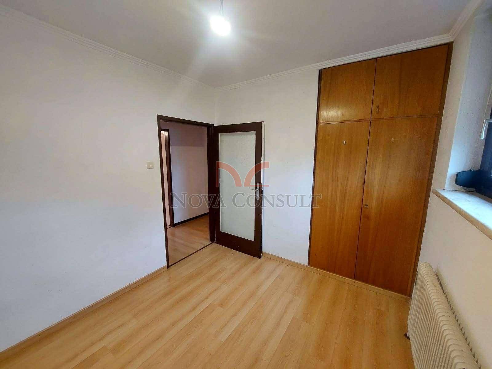 Geräumiges Zimmer mit Laminatboden und eingebautem Holzschrank.