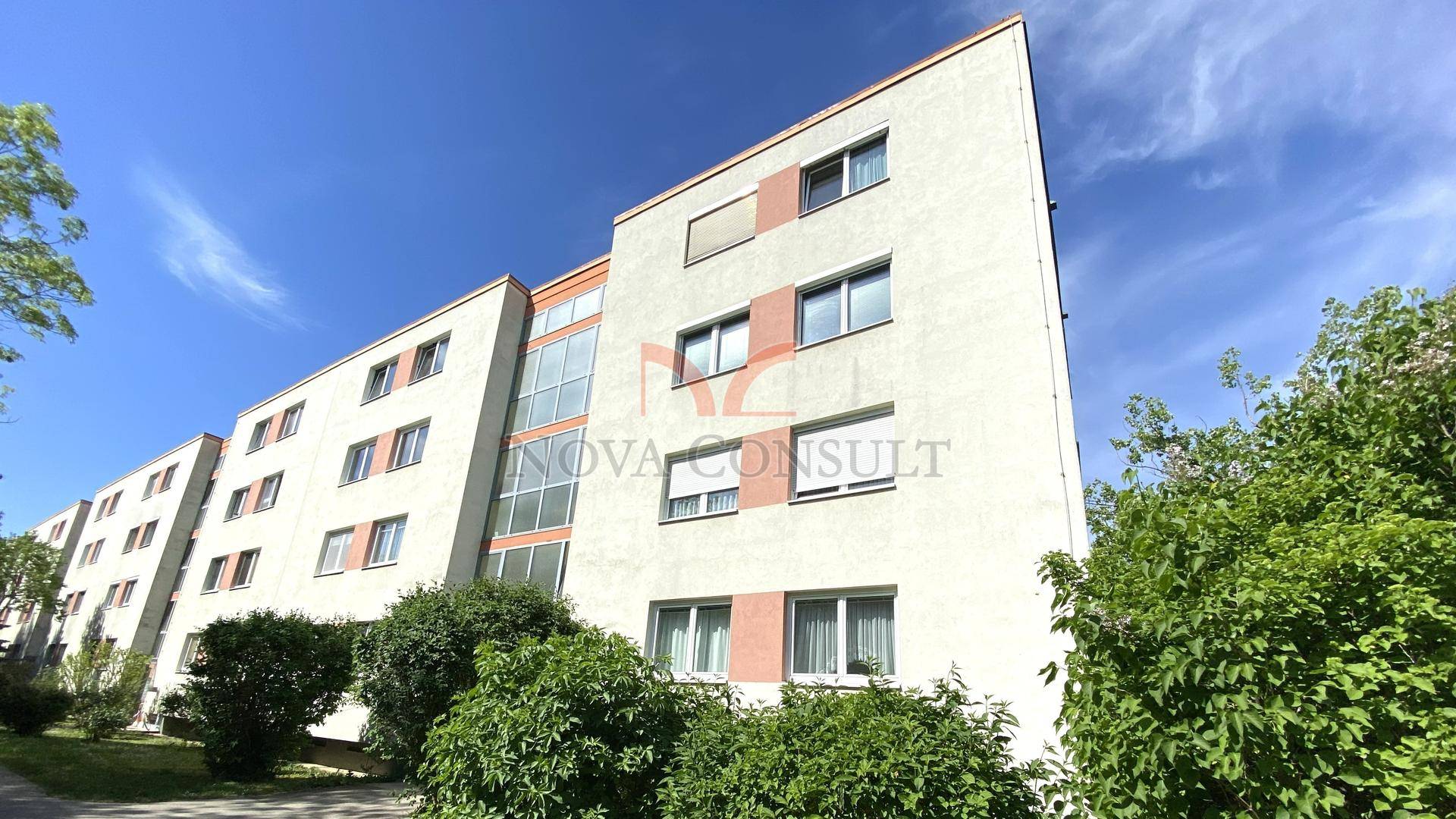 Mehrstöckiges Wohngebäude mit moderner Fassade, vielen Fenstern und Balkonen.