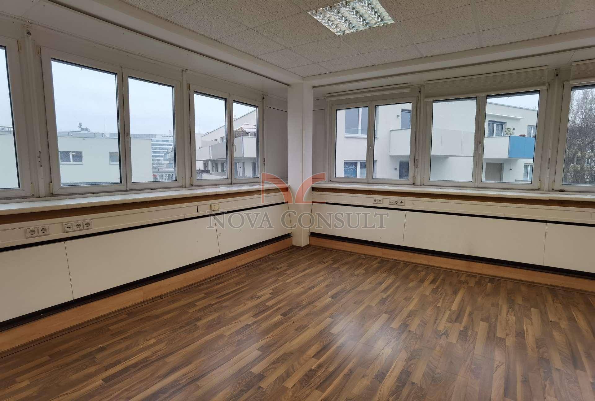 Geräumiges Büro mit vielen Fenstern, die einen weiten Blick auf die umliegende Stadt ermöglichen.
