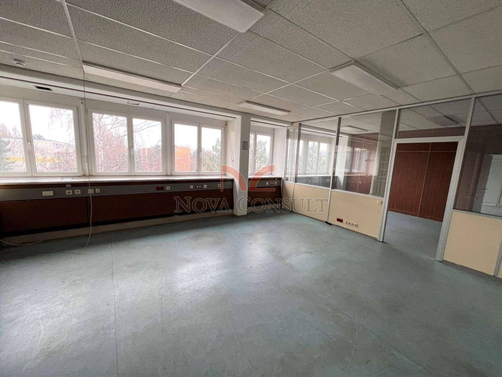 Geräumiges, leeres Büro mit großen Fenstern und Glasabtrennungen, bereit zur individuellen Gestaltung.