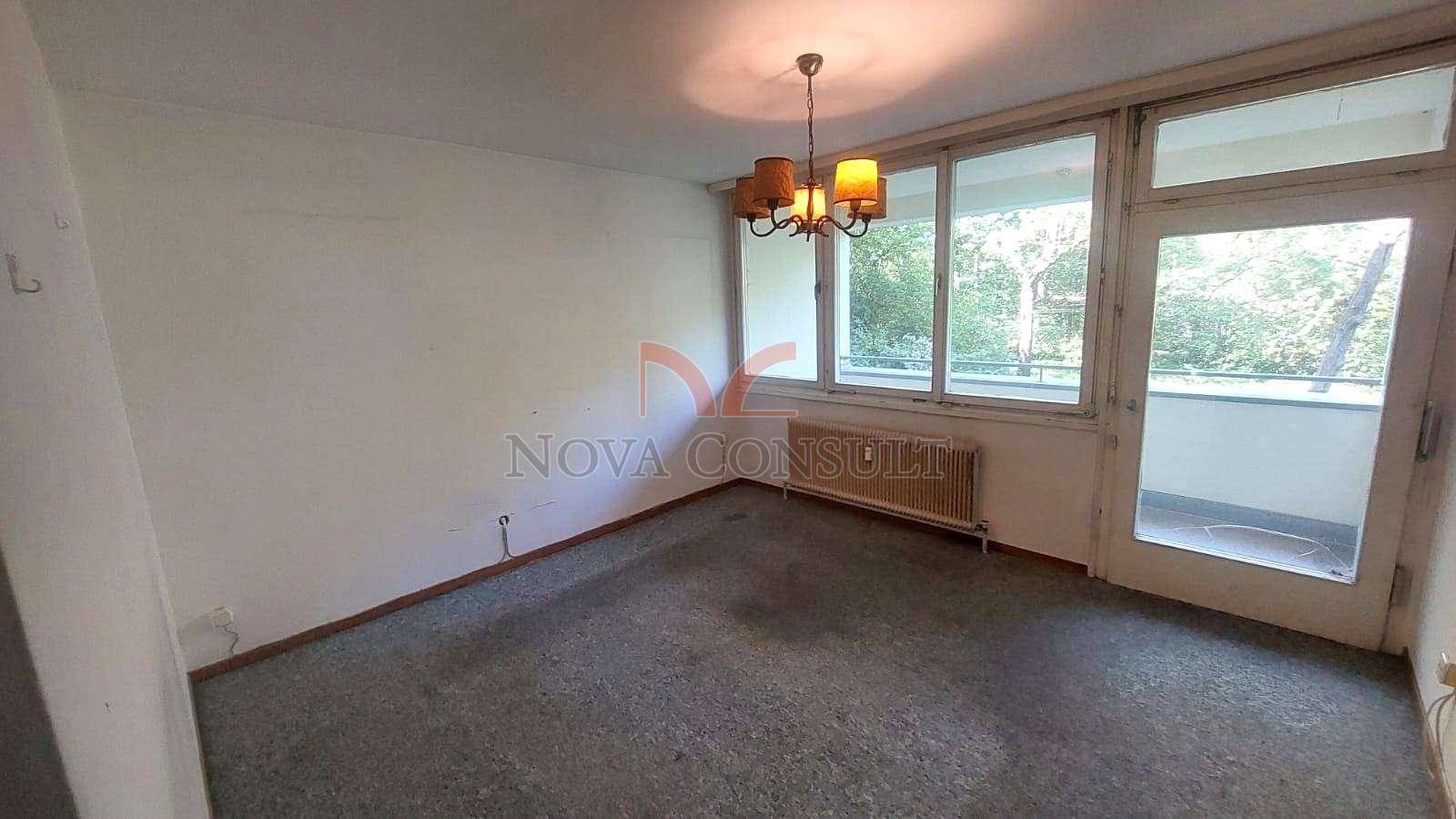 Geräumiges Zimmer mit Teppichboden, großem Fenster und Zugang zu einem Balkon.