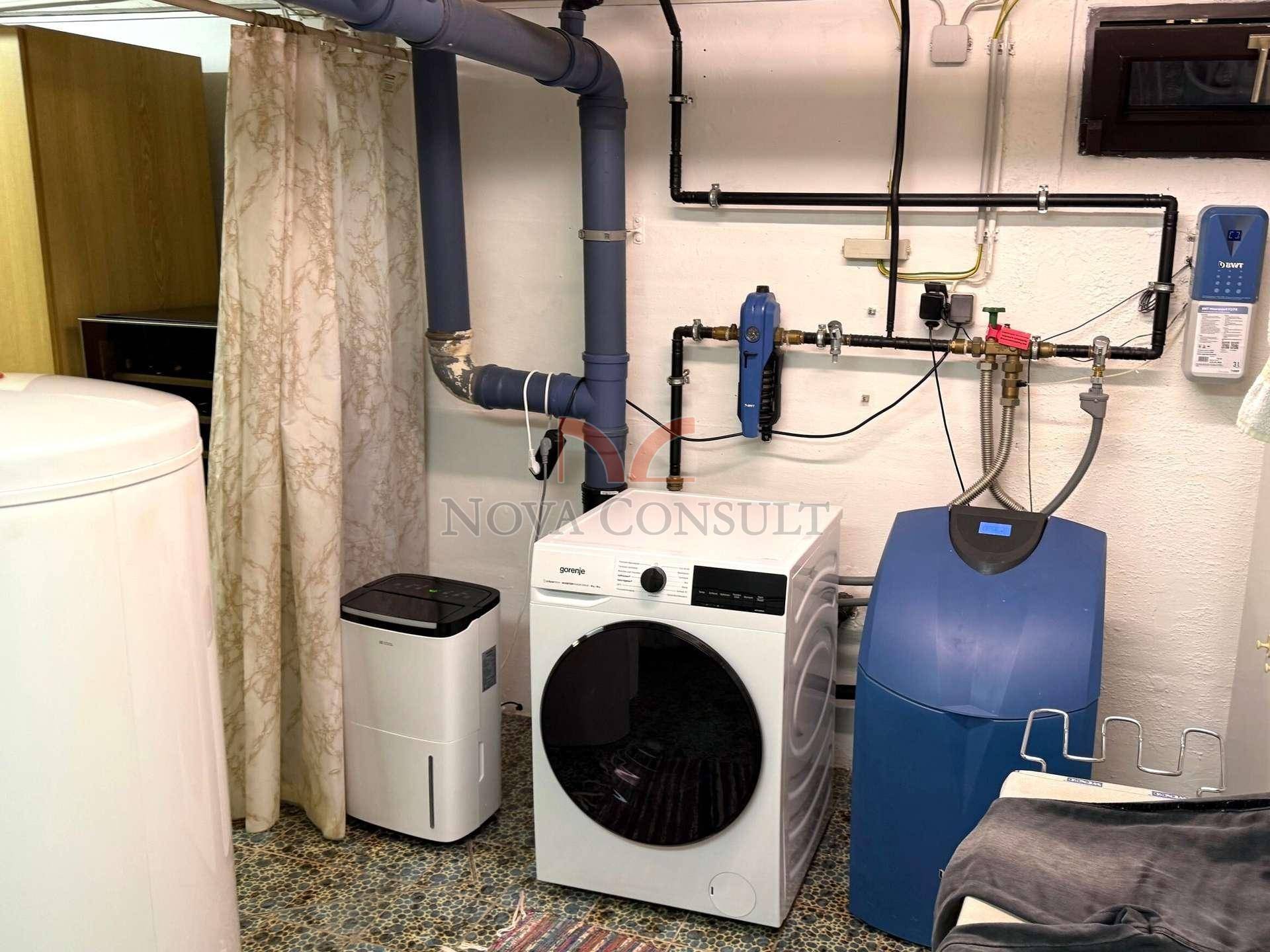 Hauswirtschaftsraum im Keller mit Waschmaschine, Trockner und Wasseraufbereitungsanlage.