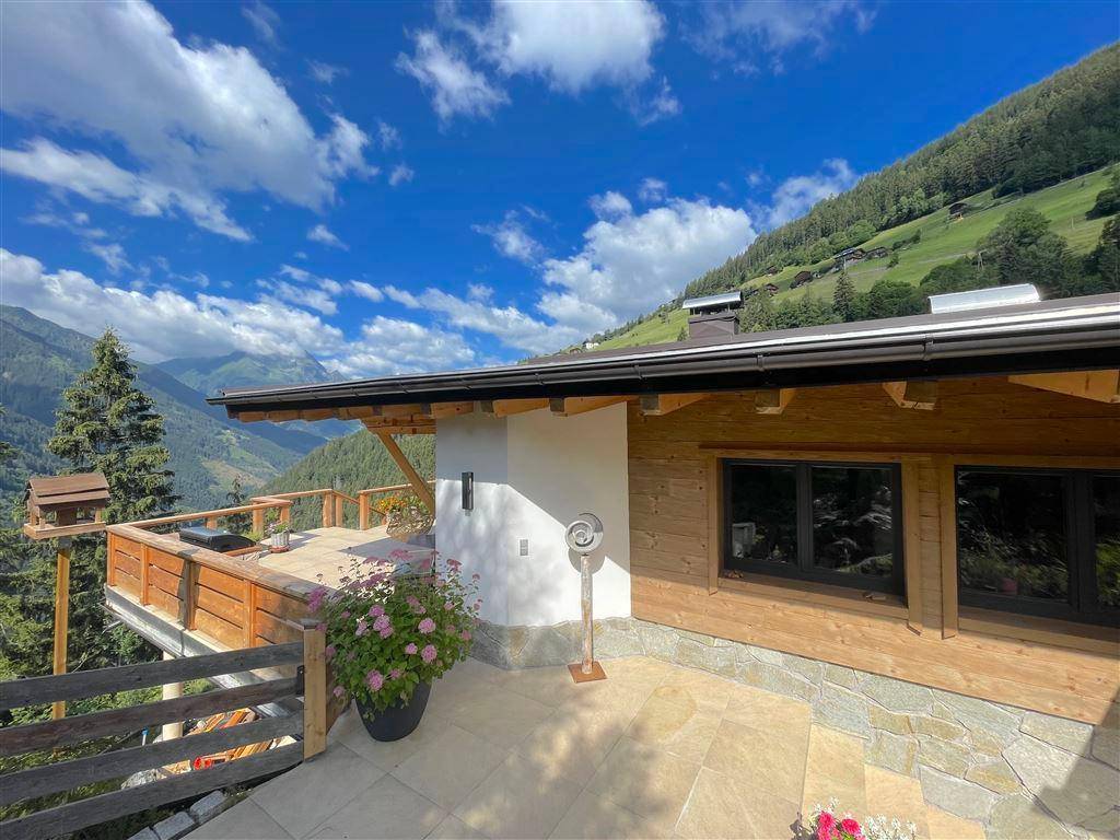 Außenansicht des Hauses mit Terrasse und weitem Blick auf die umliegende Berglandschaft.