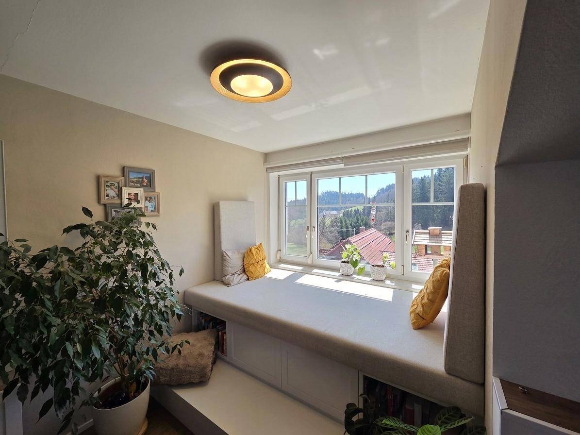 Heller Fensterplatz mit bequemer Polsterung und Blick auf die umliegende grüne Landschaft.