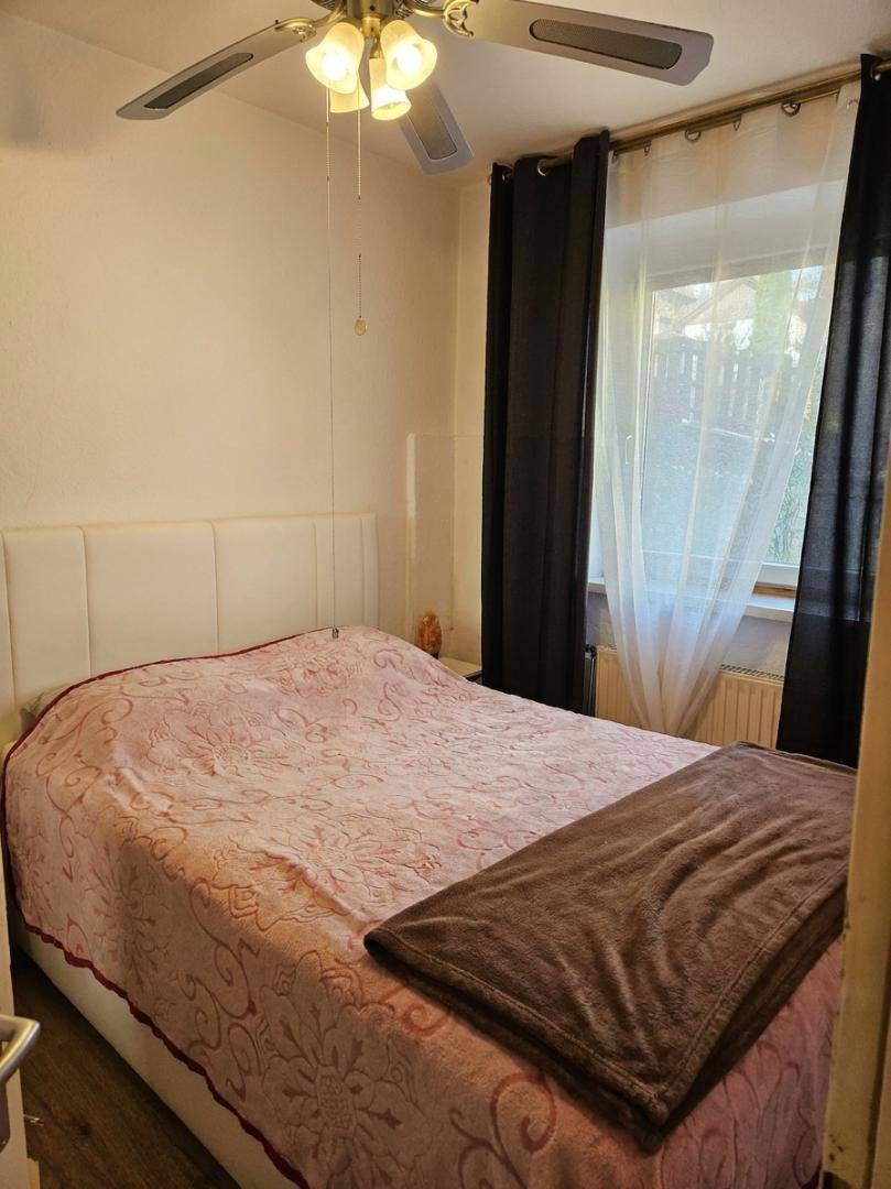 Gemütliches Schlafzimmer mit Doppelbett, Deckenventilator und Blick ins Grüne.