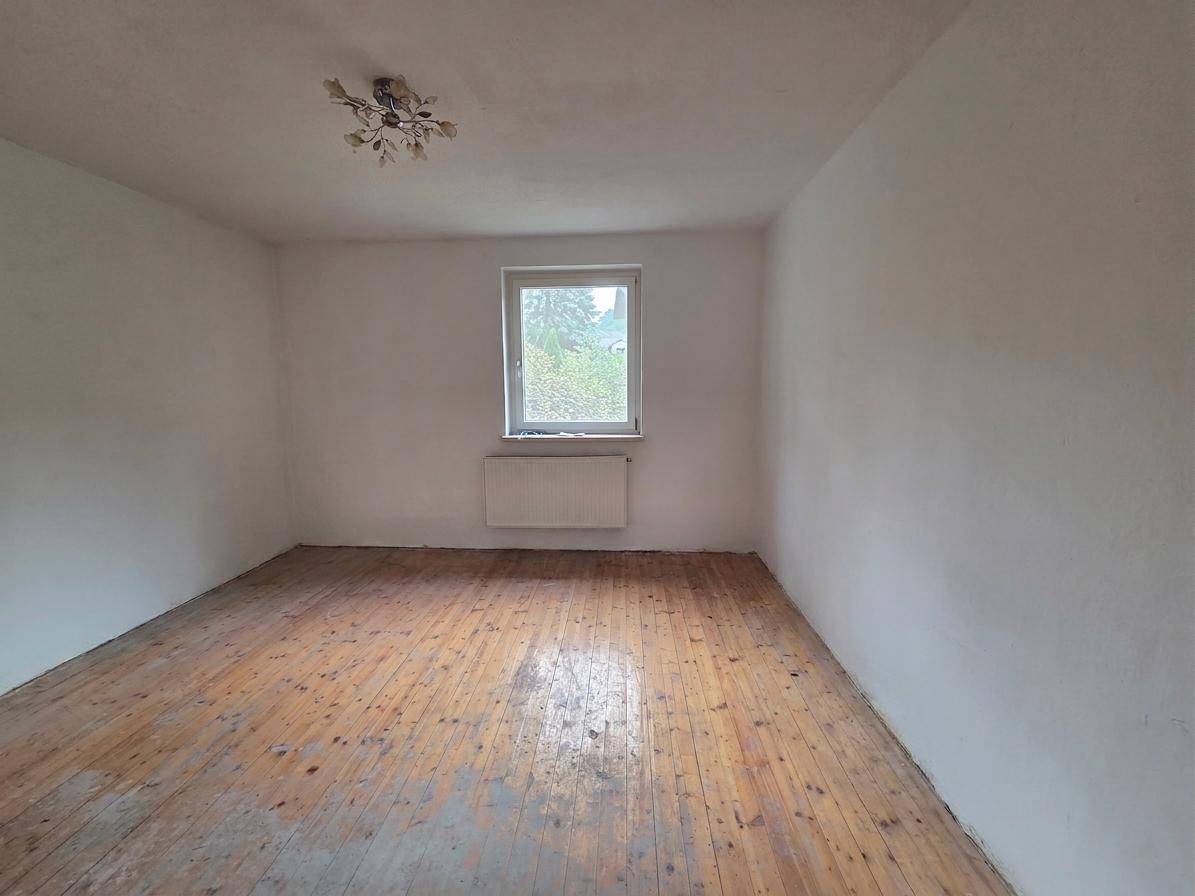 Leerer Raum mit Holzdielenboden und Fenster, bereit zur individuellen Gestaltung.