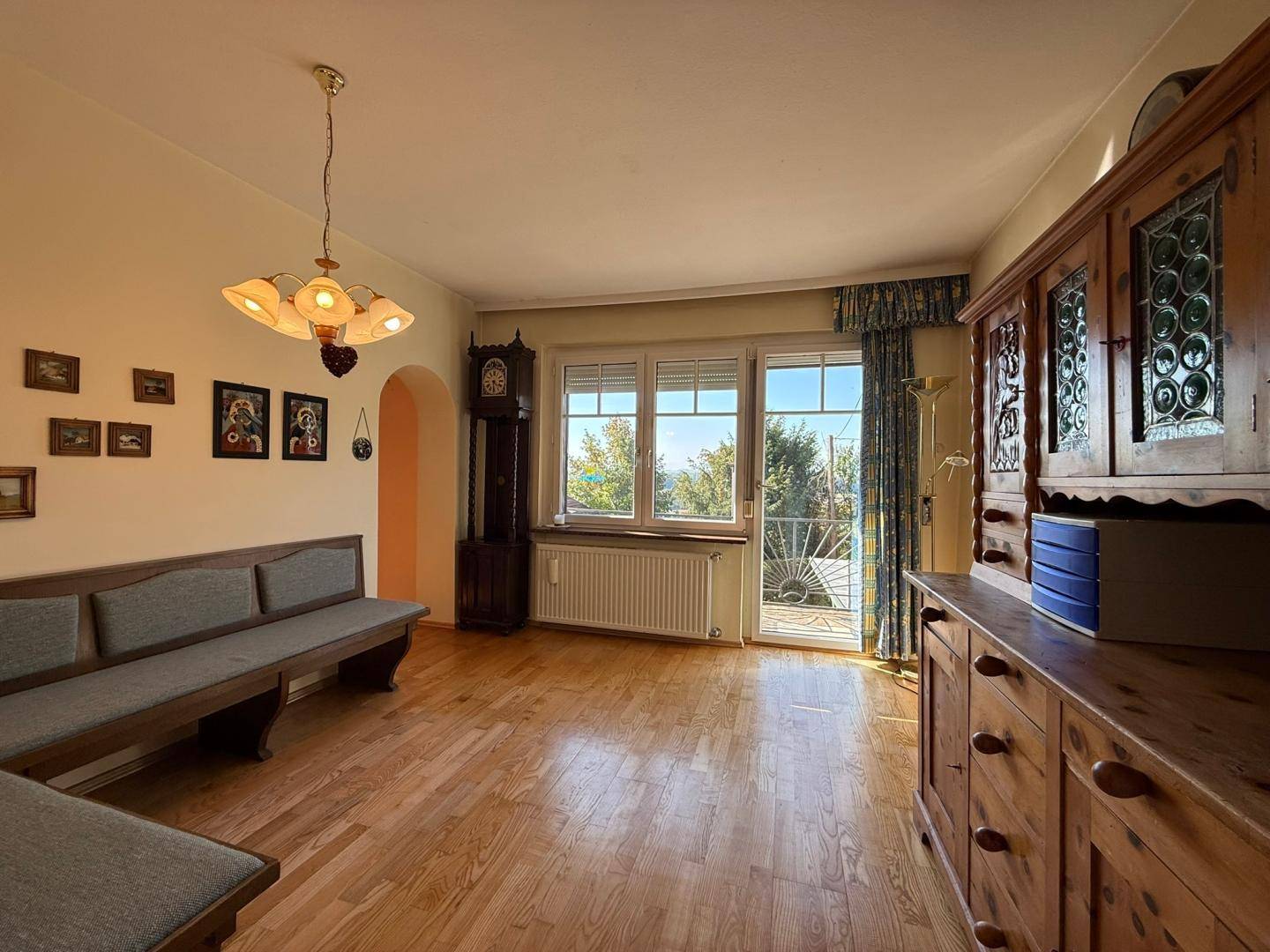 Traditionell eingerichtetes Wohnzimmer mit Holzboden und Zugang zum Balkon.