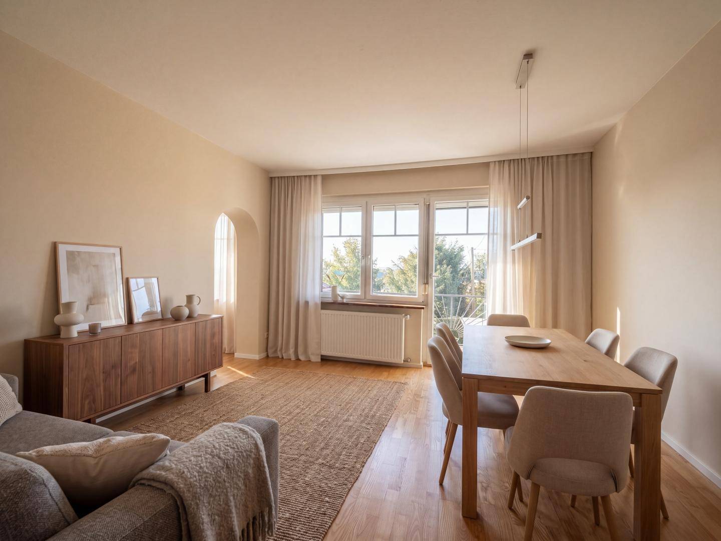 Modern gestalteter Wohn- und Essbereich mit Holzboden und großem Fenster.