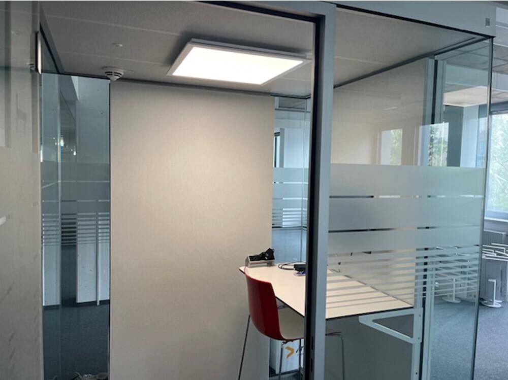 Kleiner, moderner Büroraum mit Glaswänden und einem einzelnen Arbeitsplatz.