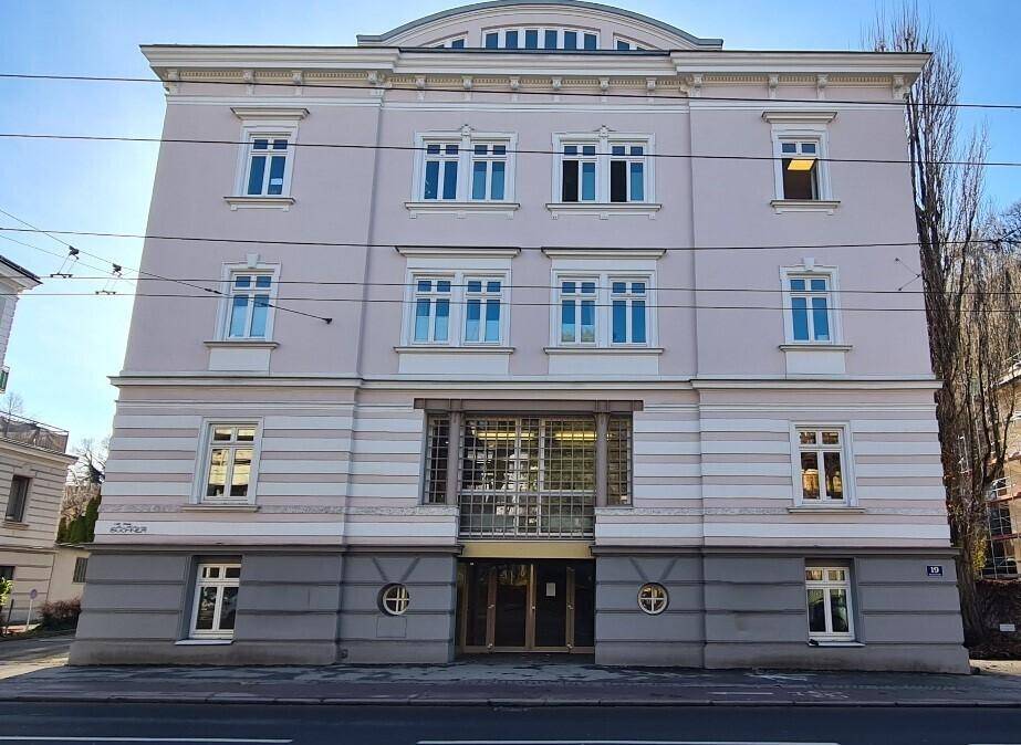 Klassisches Mehrfamilienhaus mit eleganter Fassade, vielen Fenstern und einem markanten Eingangsbereich.