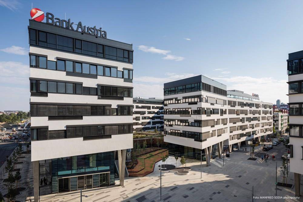 Nahaufnahme eines modernen Bürogebäudes mit der Aufschrift "Bank Austria" und einem einladenden Eingangsbereich.