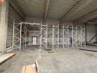Weitläufige Lagerhalle mit hohen Decken und umfangreichen Metallregalsystemen für die Lagerung.