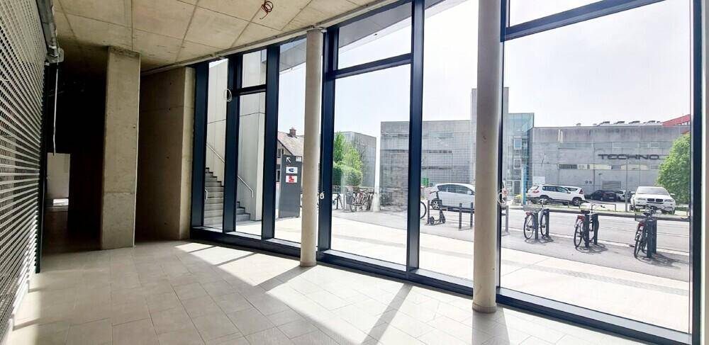 Heller Gewerberaum mit großen Fenstern, die einen Blick auf die Straße und die umliegenden Gebäude bieten.
