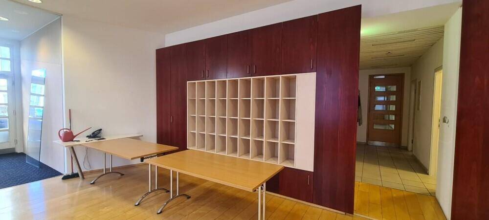 Büroraum mit Holzboden, großen Einbauschränken und Regalen für Organisation und Lagerung.