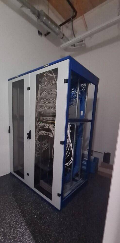 Serverraum mit Verkabelung und technischen Geräten, für die IT-Infrastruktur des Gebäudes.