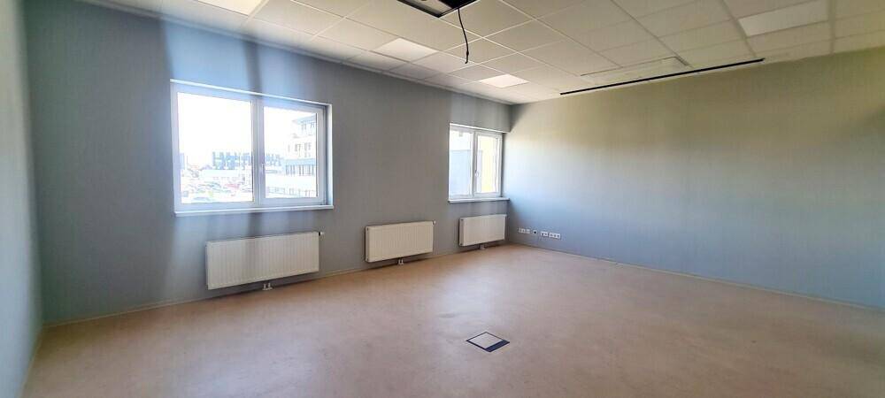 Geräumiger Büroraum mit drei Fenstern und Heizkörpern, ausgestattet mit einer abgehängten Decke und viel Licht.