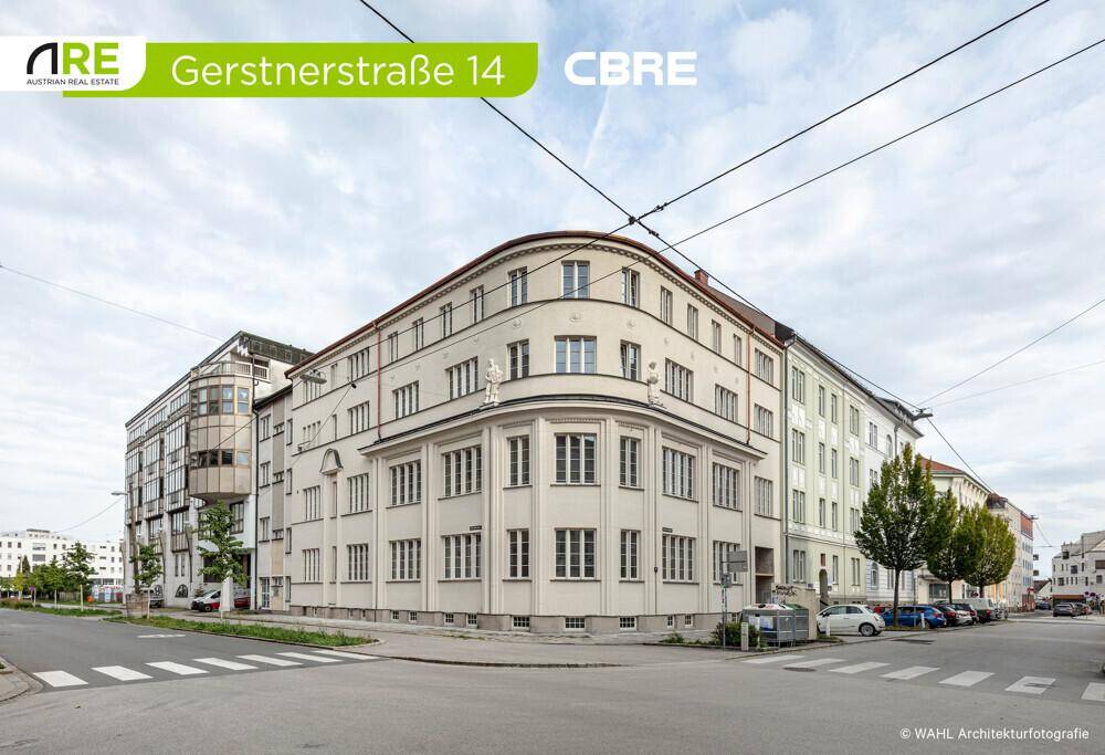 Ansicht des Gebäudes von der Straße mit einer markanten, geschwungenen Fassade und vielen Fenstern.
