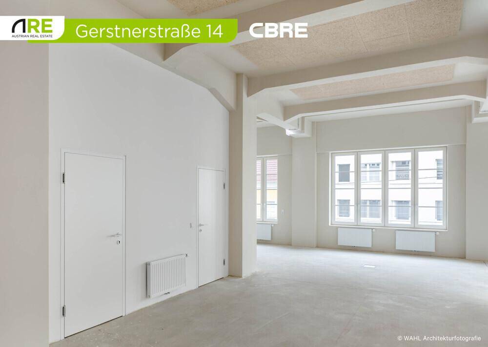 Leerer Büroraum mit einer Wand, die zwei Türen und einen Heizkörper zeigt, bereit für die Innenausstattung.