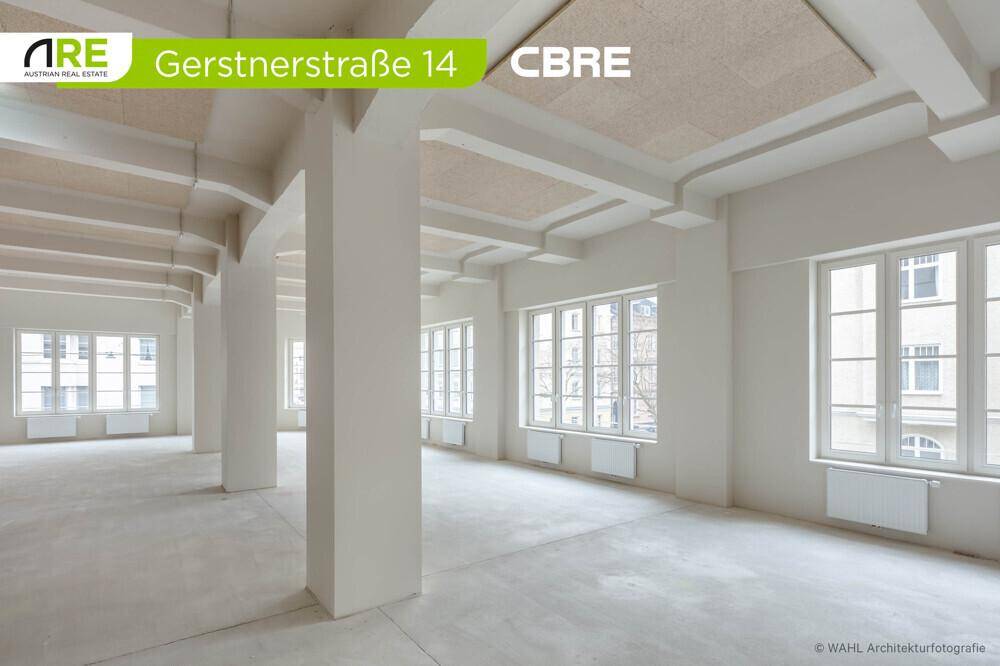 Weitläufiger Büroraum mit zahlreichen Fenstern, die viel Tageslicht hereinlassen, und einer klaren, funktionalen Ästhetik.