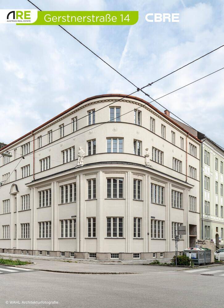 Detailansicht der eleganten, geschwungenen Gebäudefassade mit klassischen Fenstern und architektonischen Details.