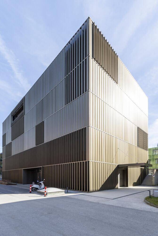 Architektonisch ansprechendes, modernes Gebäude mit vertikalen Lamellen und einem Eingangsbereich.