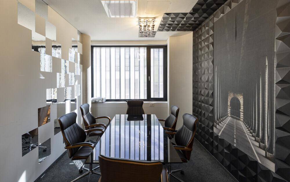 Stylischer Konferenzraum mit dunklem Teppich, strukturierten Wänden und großem Fenster.