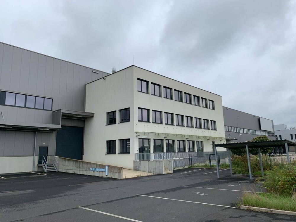 Moderner Büroanbau des Logistikkomplexes mit vielen Fenstern und Zufahrt.