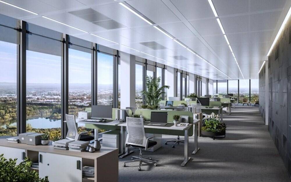 Geräumiges Büro mit vielen Arbeitsplätzen, großen Fenstern und weitem Blick über die Stadt und einen See.