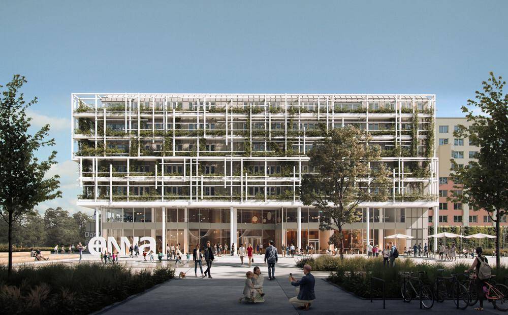 Ansicht des Haupteingangs eines modernen Gebäudes mit vertikaler Begrünung und großen Glasflächen, belebt mit Menschen.